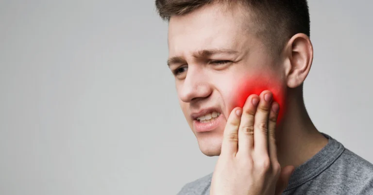 Frustrated young man touching his tooth and frowning face